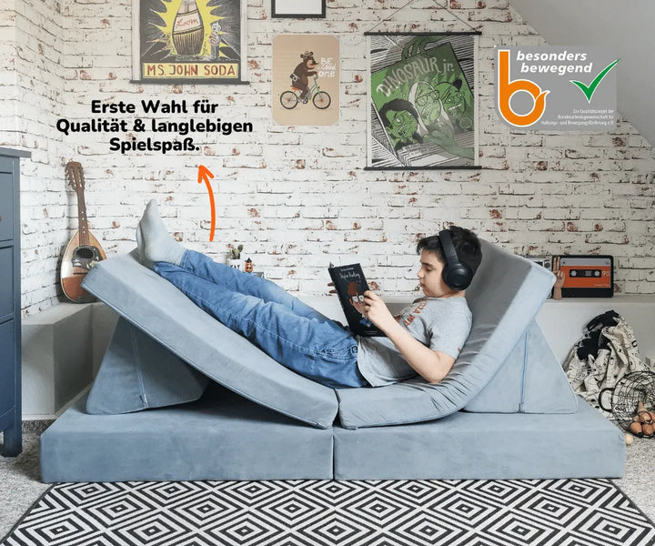 Kind liest auf Spielsofa #farbe_mond-grau